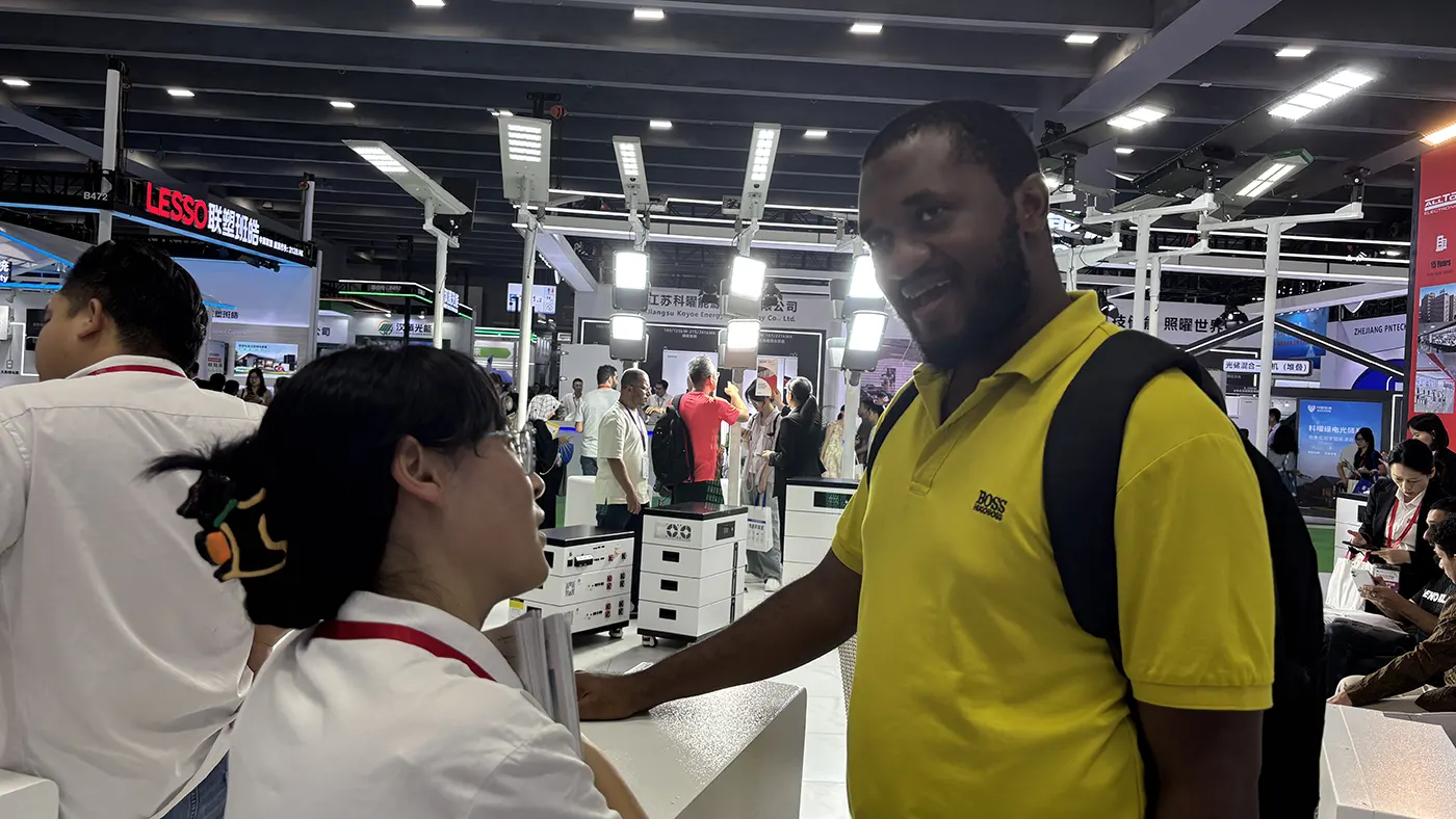 GODE sales representative discussing solar PV and energy storage solutions with a client at PV Guangzhou 2025