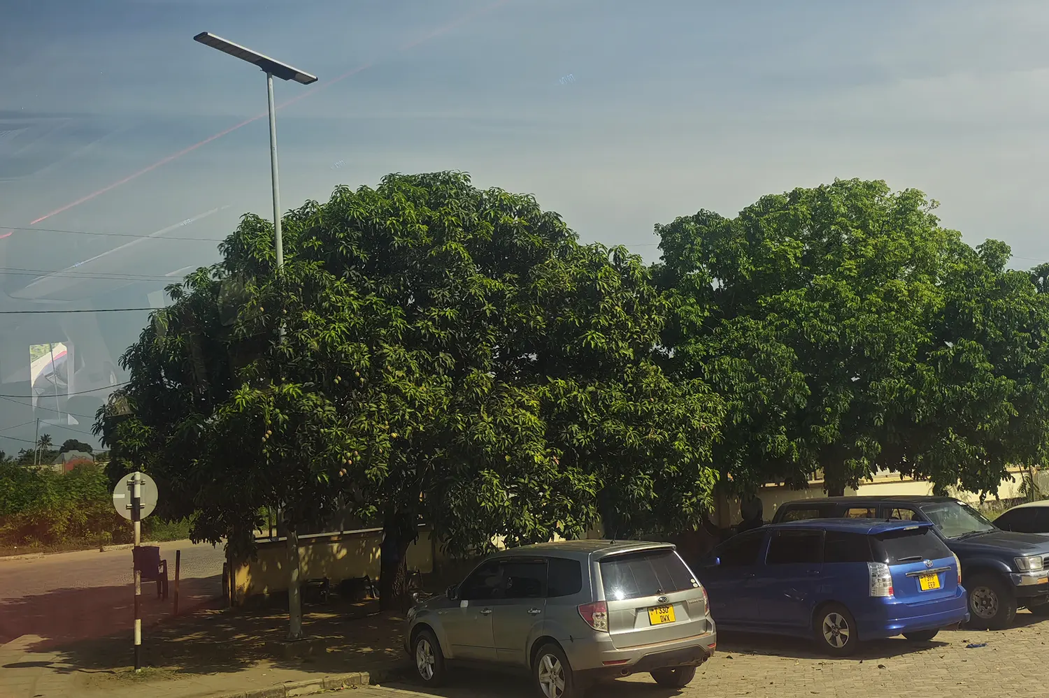 Close-up view of the GODE 0477 Series 300W all-in-one solar LED street light mounted at a bus station entrance in Tanzania, highlighting integrated solar panel and durable outdoor design.