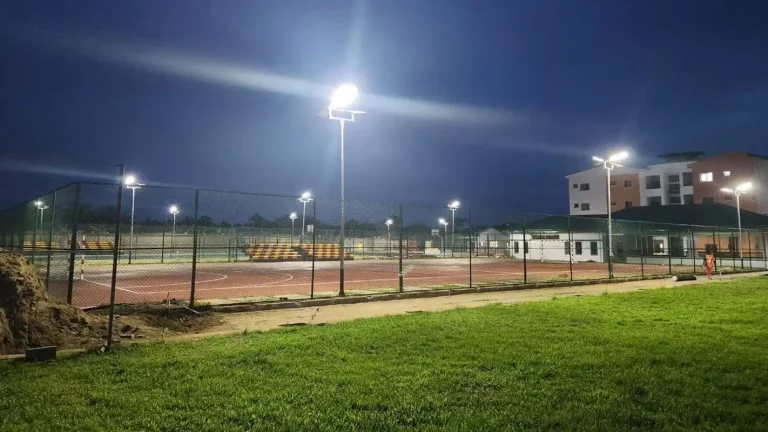Nighttime view of a basketball court lit by GODE 150W 0418 Series Solar Street Lights, showing bright and uniform lighting.
